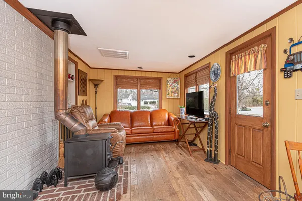 a living room with furniture a flat screen tv and a large window