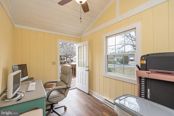 a work room with furniture a flat screen tv and a window