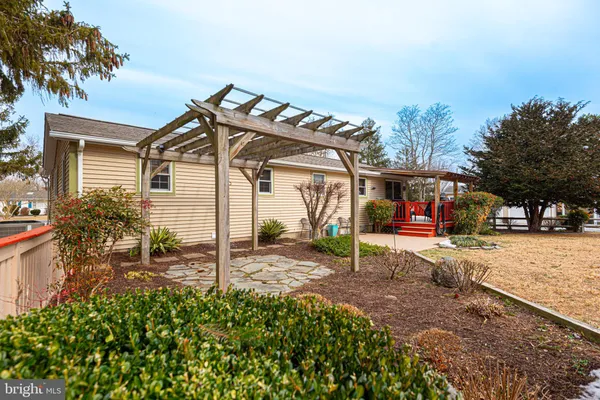 a view of a white house with a yard and sitting area