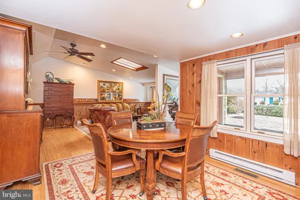 a dining room with furniture a large window and a chandelier