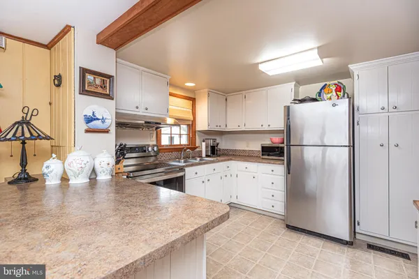 a kitchen with a refrigerator a stove top oven and a counter space