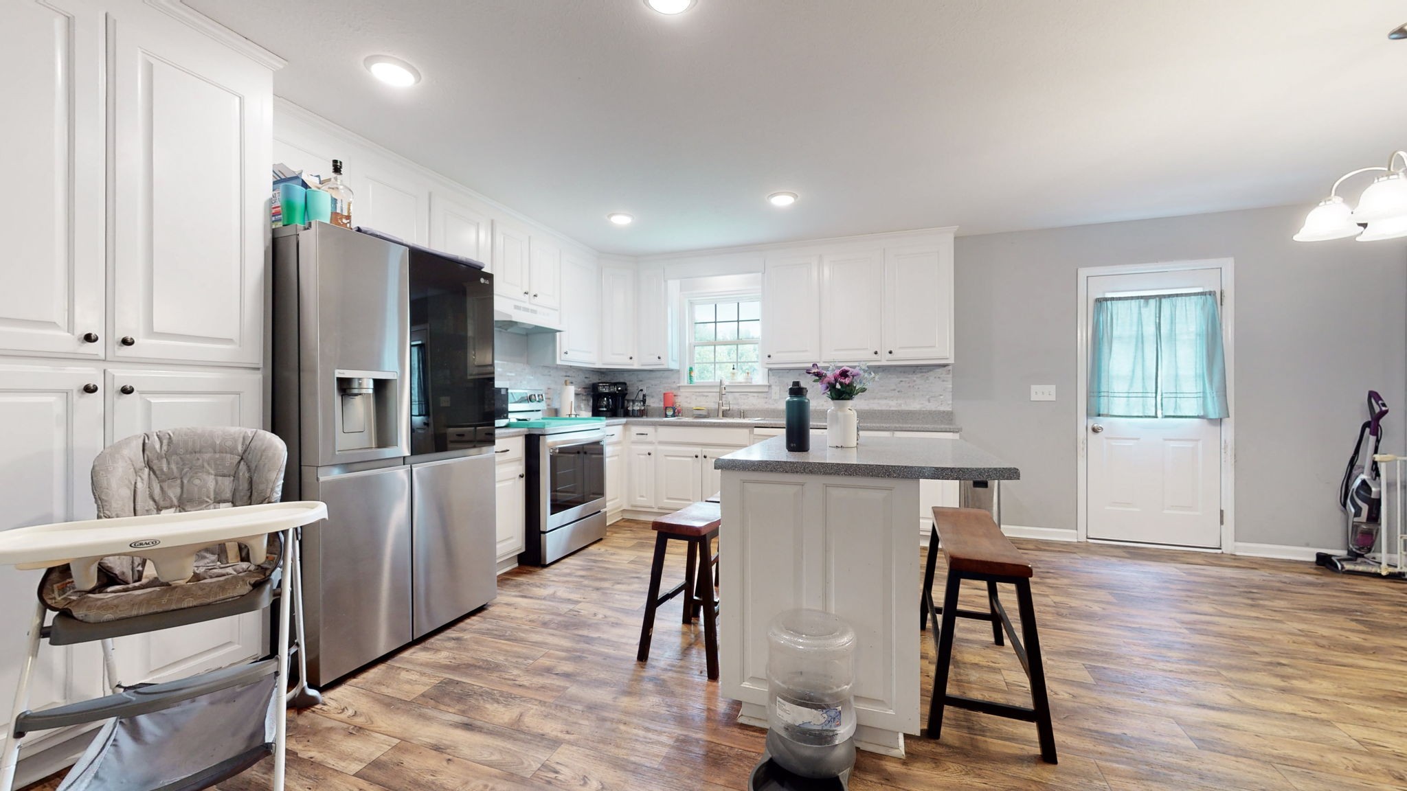 7018 Charity Road Petersburg, TN 37144 - Photo 10 of 25 a kitchen with a refrigerator a stove top oven a sink dishwasher and white cabinets with wooden floor