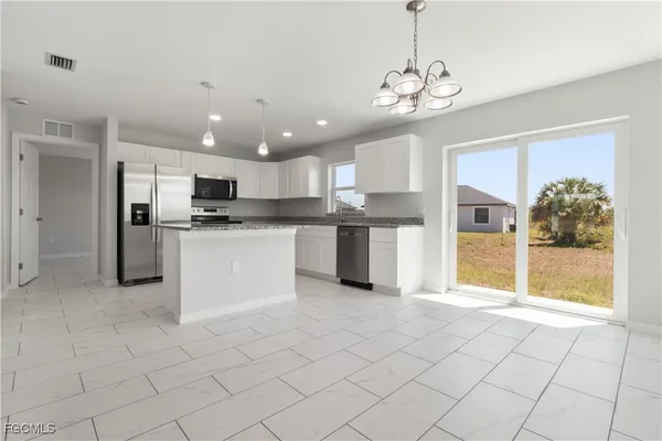 a view of a kitchen with microwave and refrigerator