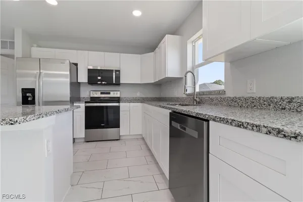 a kitchen with stainless steel appliances granite countertop a stove a sink and a granite counter tops