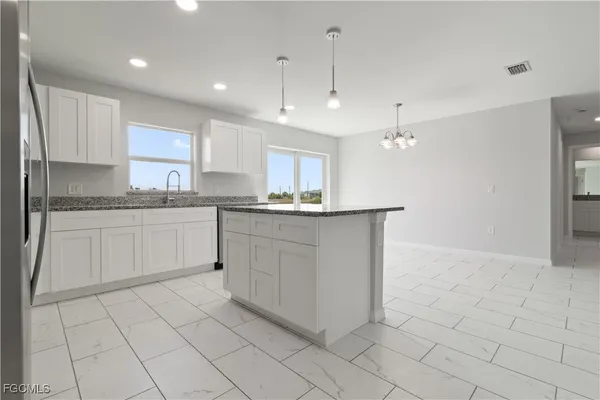 a kitchen with a sink window and cabinets