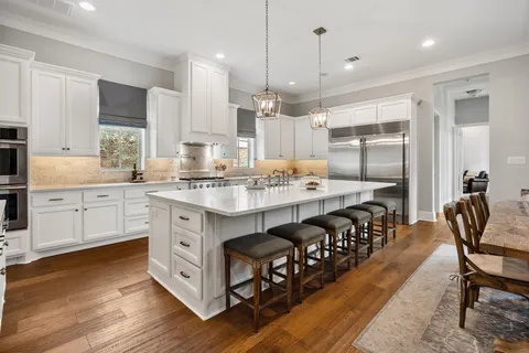 a kitchen with granite countertop a sink appliances cabinets and wooden floor