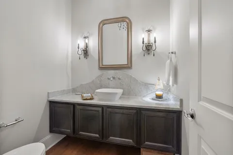 a bathroom with a granite countertop sink a toilet and a mirror