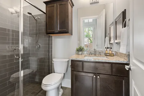 a bathroom with a granite countertop sink toilet and shower