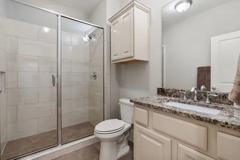 a bathroom with a granite countertop sink toilet and shower