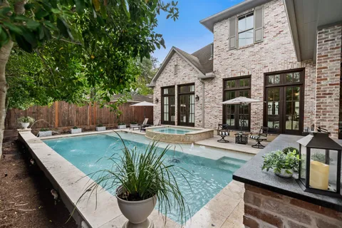 a view of a backyard with couches plants and large tree