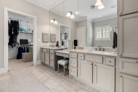 a large white kitchen with a sink and cabinets