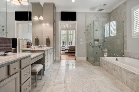 a large bathroom with a double vanity sink a large mirror and a bathtub