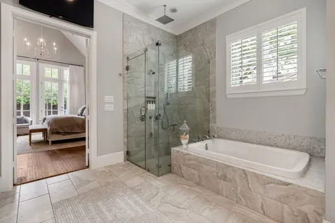 a spacious bathroom with a tub shower and windows
