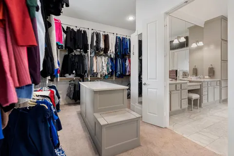 a view of walk in closet with clothes and shoes