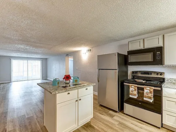 a kitchen with kitchen island a sink stainless steel appliances and window