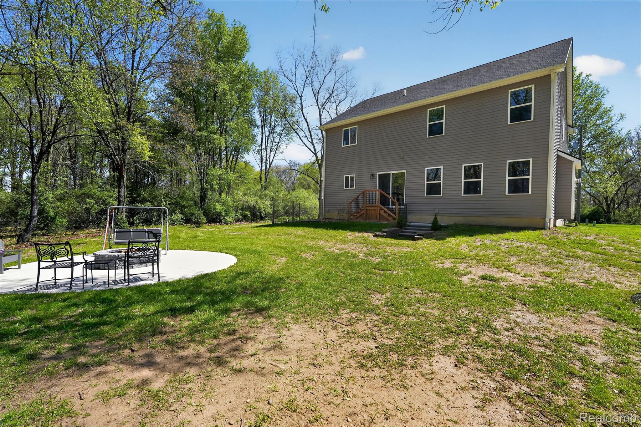 8130 Hinchey Road Pinckney, MI 48169 - Photo 46 of 62 Rear view of property featuring a lawn and a patio