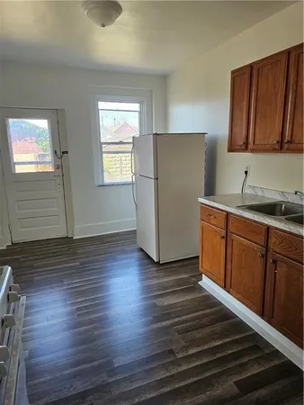a kitchen with cabinets and wooden floor
