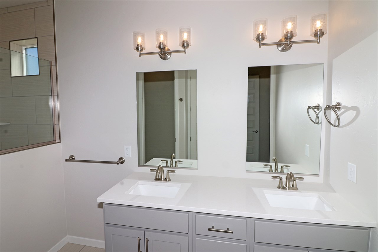 810 Rupp Avenue Palisade, CO 81526 - Photo 14 of 27 a bathroom with double vanity sinks a vanity a lamp and a mirror