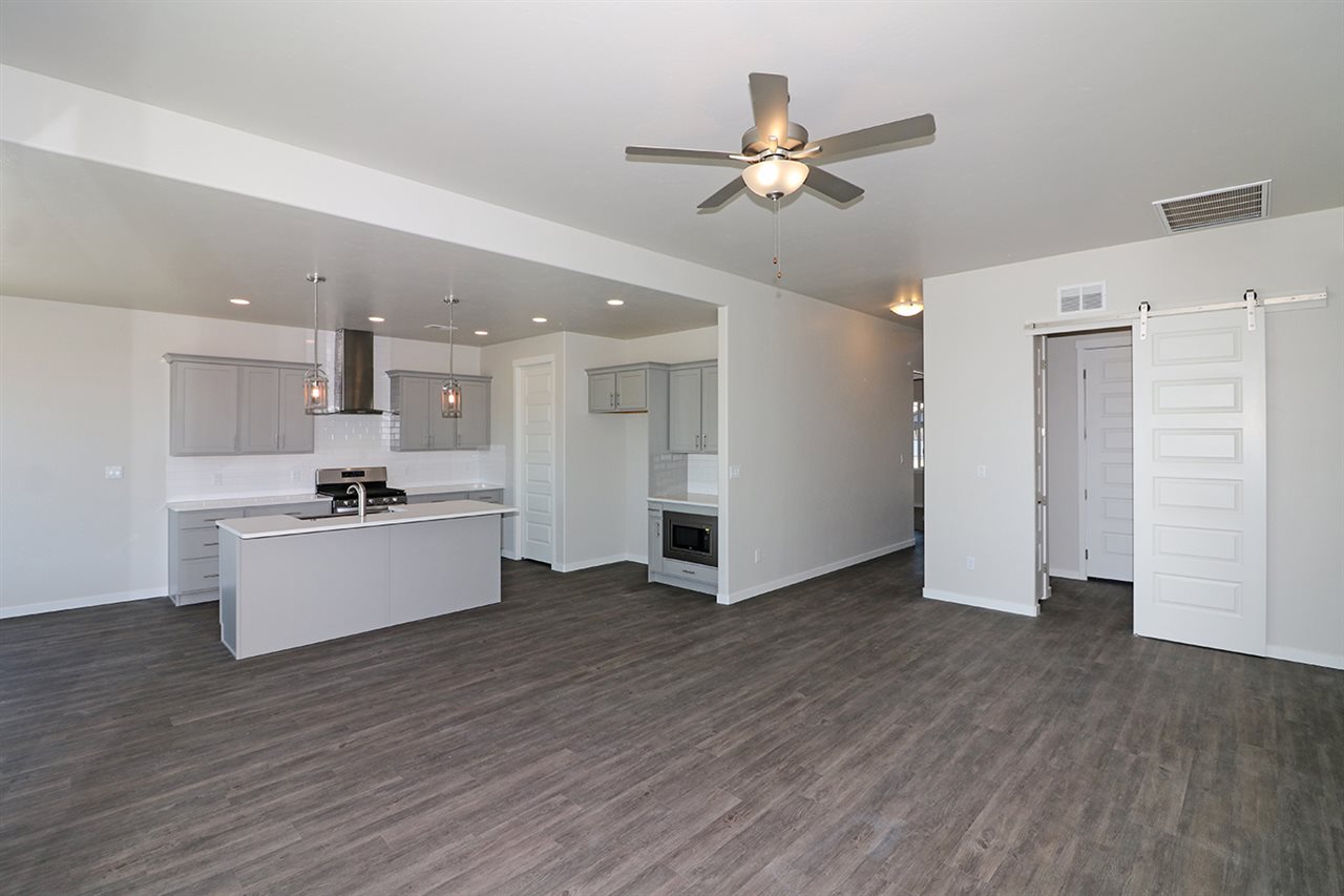 810 Rupp Avenue Palisade, CO 81526 - Photo 4 of 27 a view of an empty room with wooden floor and a kitchen