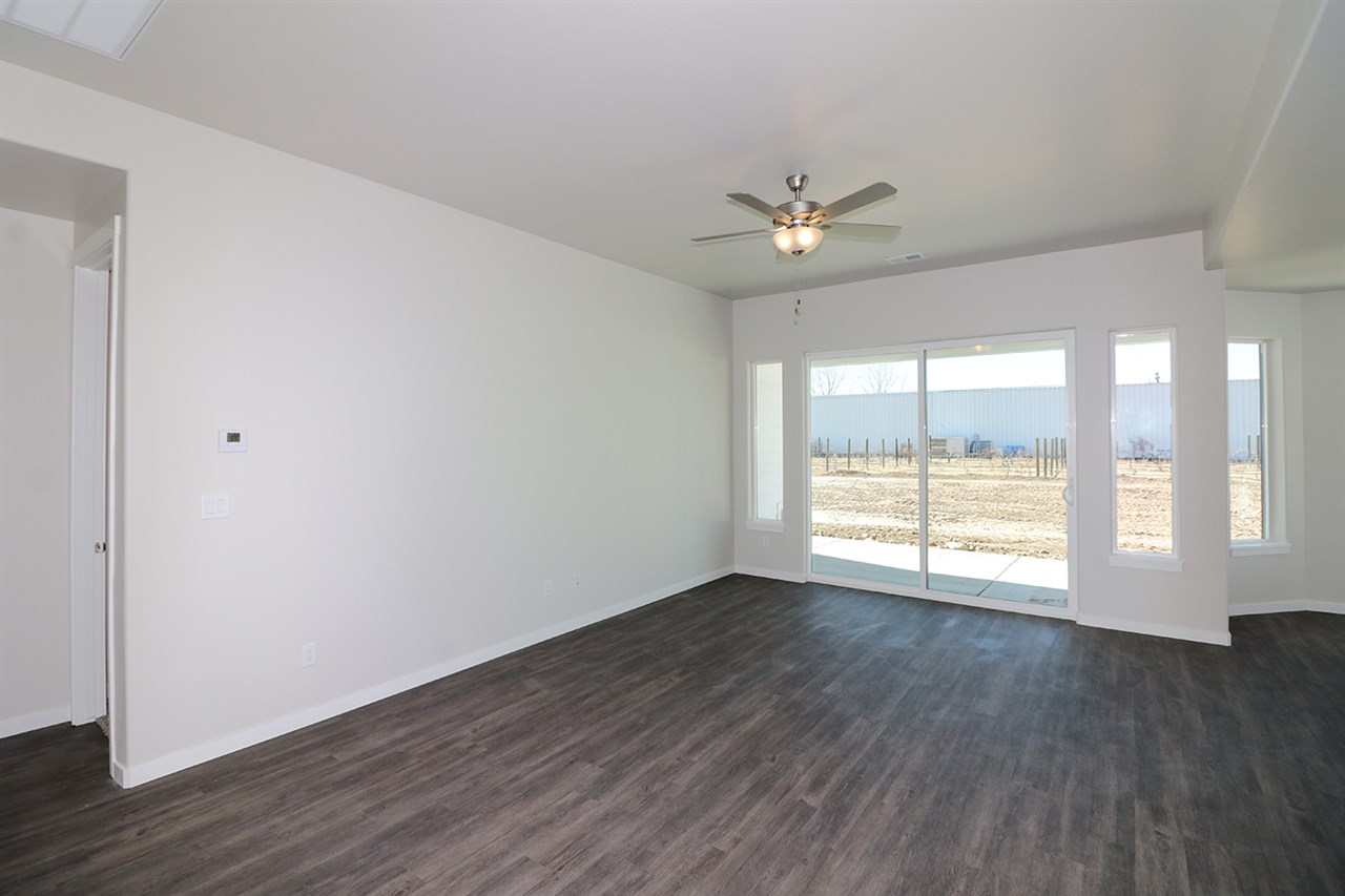 810 Rupp Avenue Palisade, CO 81526 - Photo 10 of 27 an empty room with wooden floor and windows