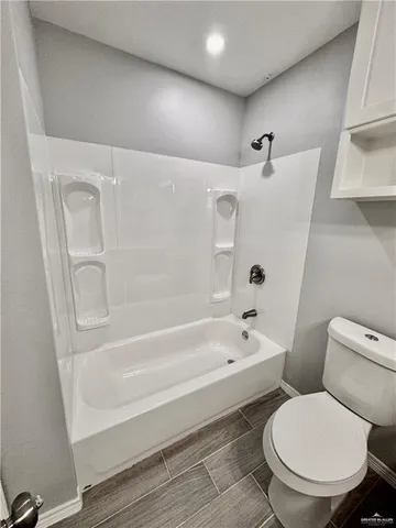 a white toilet sitting next to a bath tub