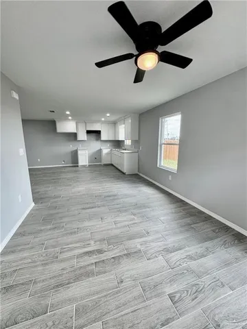 a view of empty room with wooden floor and window