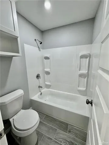 a bathroom with a toilet and a bath tub