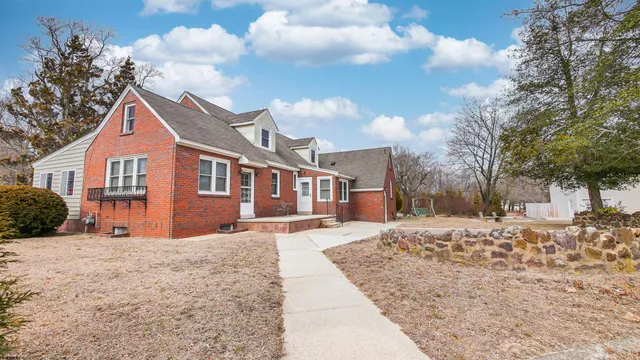 a kitchen with stainless steel appliances granite countertop a sink a stove a refrigerator and white cabinets