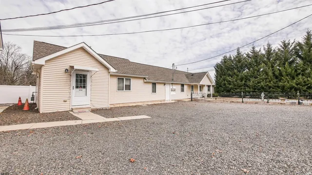 a front view of a house with a yard covered in snow