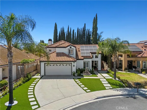 a front view of a house with a yard and potted plants