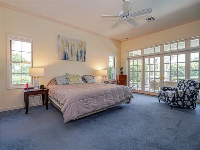 a spacious bedroom with a bed and a chandelier