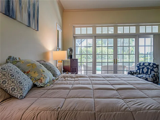 a bedroom with a bed and a large window