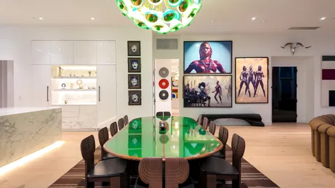 a dining room with furniture and painting on the wall