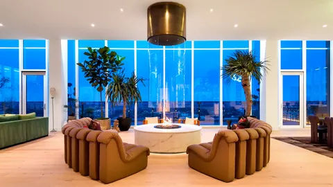 a living room with furniture fireplace and palm tree