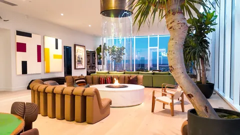 a living room with furniture fireplace and palm tree