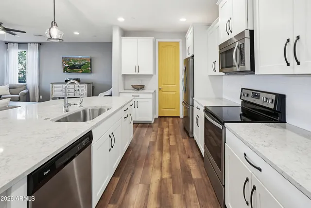 a kitchen with stainless steel appliances granite countertop sink stove and refrigerator