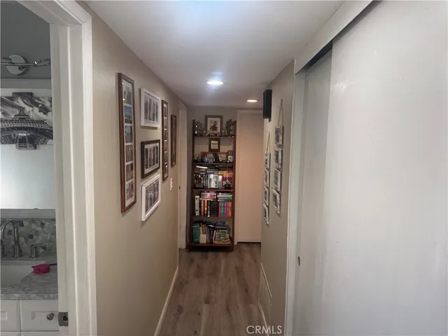 a view of a hallway with wooden floor and closet