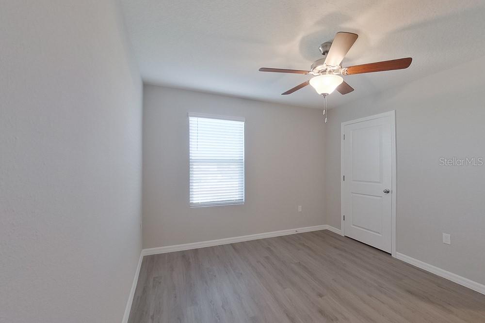 4397 Southwest 85th Lane Ocala, FL 34476 - Photo 13 of 23 an empty room with wooden floor fan and windows