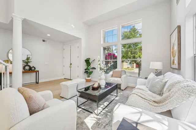 a living room with furniture fireplace and a large window