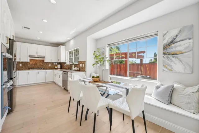 a backyard of a house with barbeque oven table and chairs