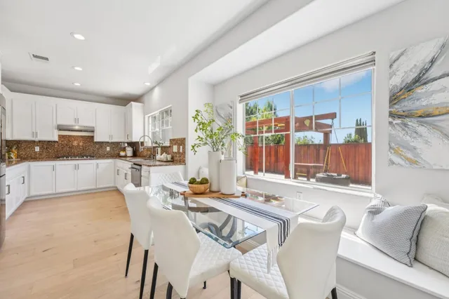 a view of a patio with table and chairs and floor to ceiling window