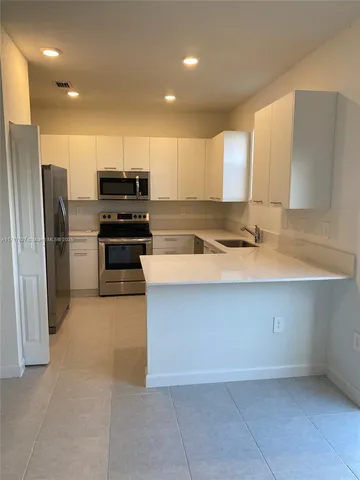 a kitchen with a refrigerator and a sink