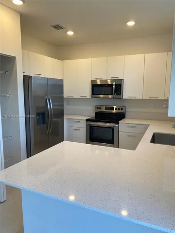 a kitchen with stainless steel appliances a refrigerator and a stove top oven