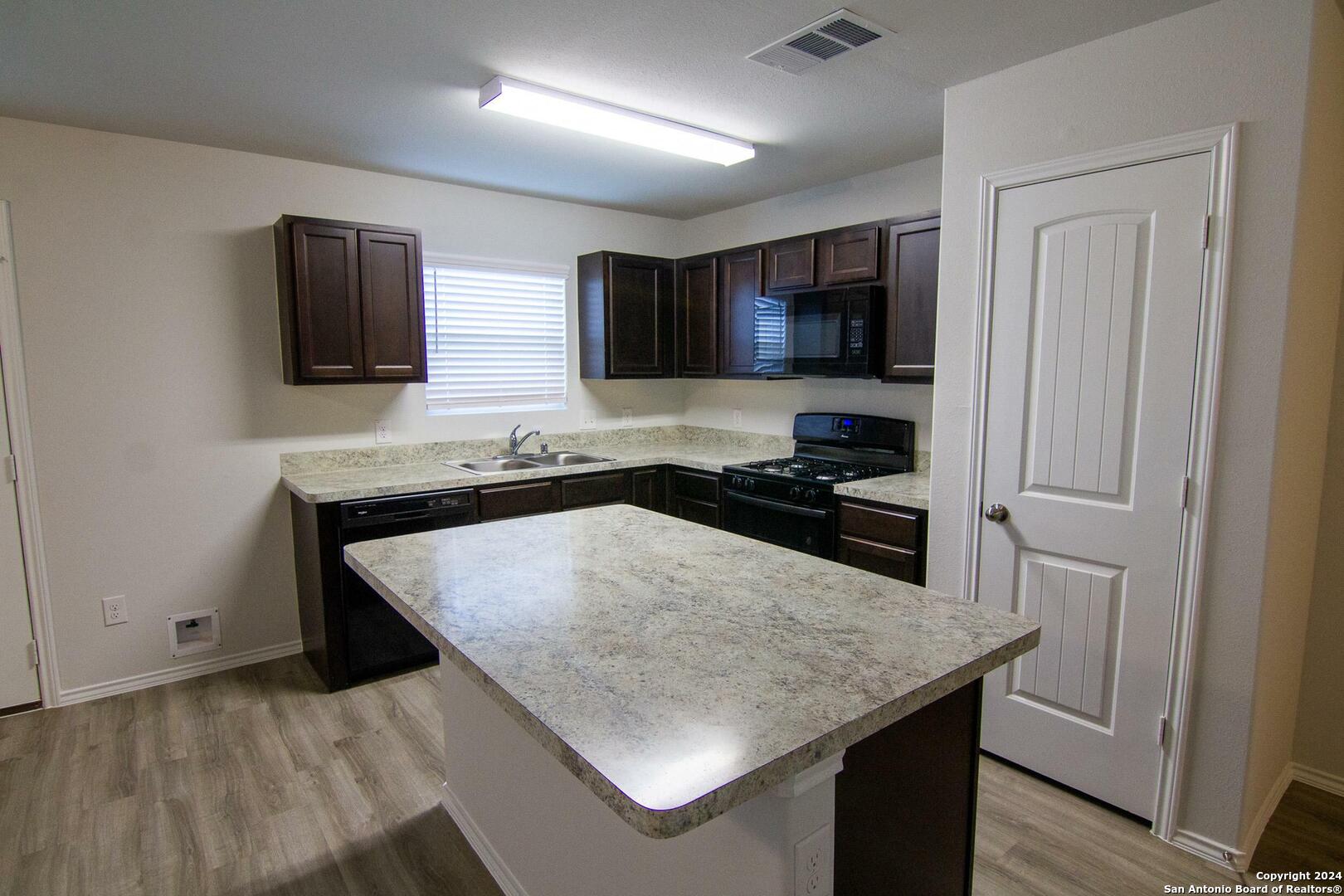 10418 Apple Pie Road San Antonio, TX 78224 - Photo 3 of 13 a kitchen with stainless steel appliances granite countertop a sink stove and refrigerator