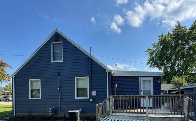 a view of a house with wooden fence and large trees