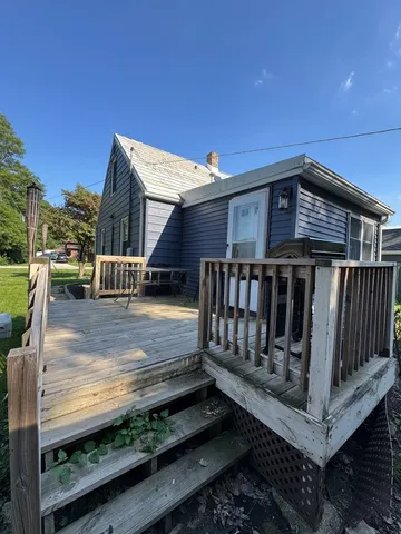 a view of wooden house with a small yard