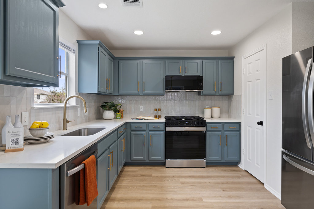 1305 Tudor House Road Pflugerville, TX 78660 - Photo 17 of 40 Clean cabinetry, updated counters, and thoughtful lighting make the kitchen a true centerpiece of the home.
