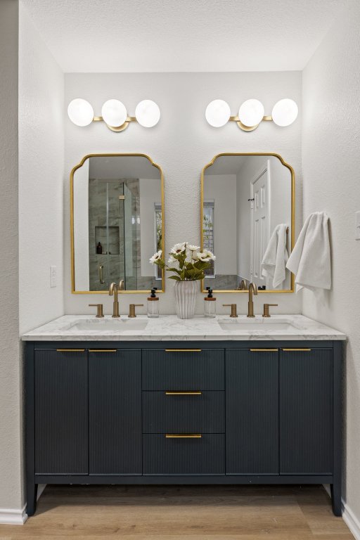 1305 Tudor House Road Pflugerville, TX 78660 - Photo 23 of 40 The upgraded primary bathroom showcases a double vanity with statement mirrors, brass fixtures, and elegant finishes throughout.