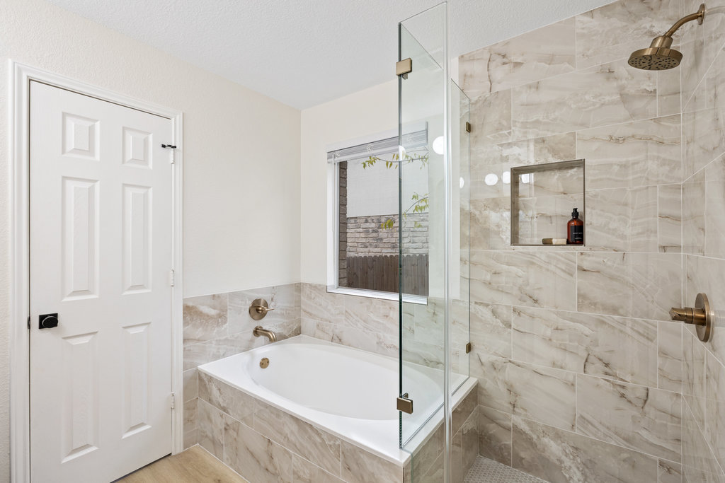 1305 Tudor House Road Pflugerville, TX 78660 - Photo 24 of 40 The soaking tub invites long, relaxing evenings, framed by timeless tilework and clean architectural lines.