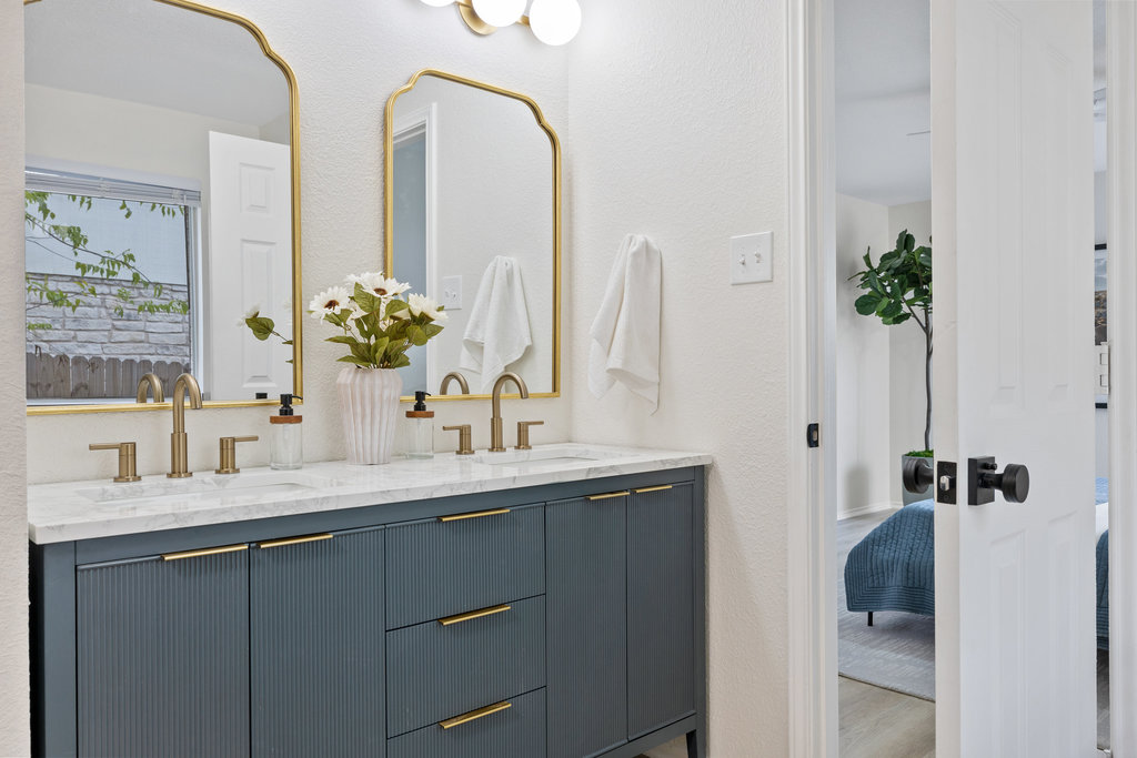 1305 Tudor House Road Pflugerville, TX 78660 - Photo 26 of 40 A closer look at the primary vanity highlights custom cabinetry, stone countertops, and warm brass accents that feel both timeless and elevated.